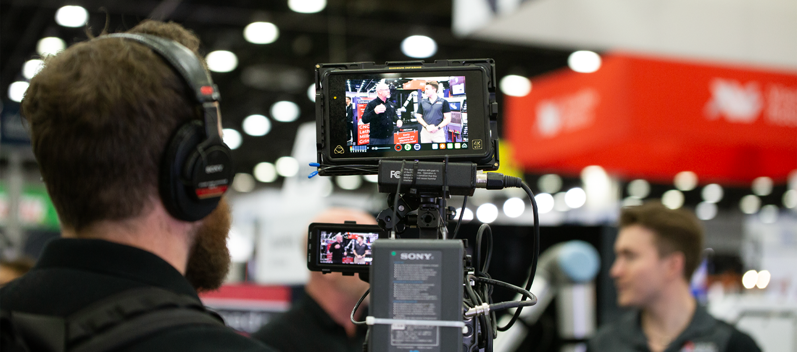 Cameraman filming in a busy convention center.