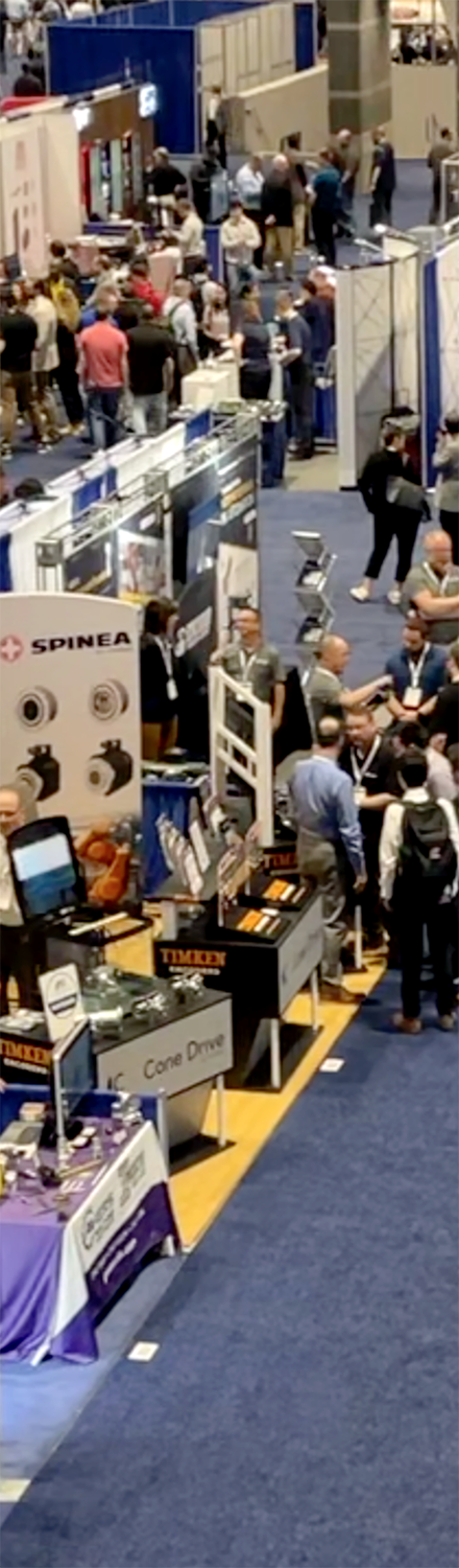 Crowded industrial exhibition with various booths and visitors.